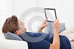 Man using digital tablet with blank screen on sofa
