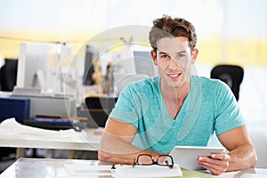 Man Using Digital Tablet In Busy Creative Office