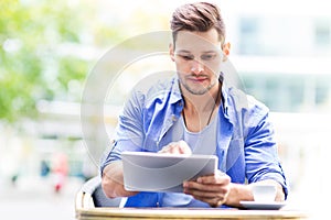 Man using digital tablet at cafe