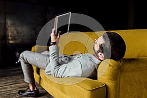 man using digital tablet while lying