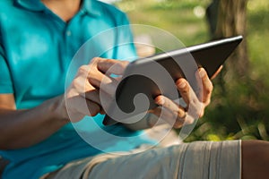 Man using a digital tablet at a park