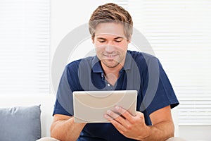 Man using digital tablet on sofa at home