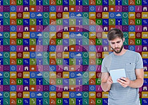 Man using digital tablet with various icons in background