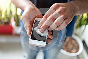 Man using a disinfection wipe on a phone