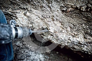 Man using a drilling tool or jackhammer to demolish