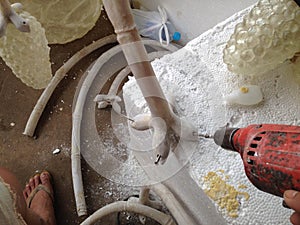 Man using an electric hand drill to drive a into resin scu