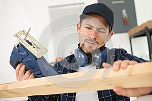 man using electric jigsaws indoors