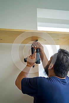 Man using an electrical drill at home. DIY, do it yourself, makeover renovation project