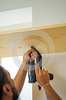 Man using an electrical drill at home. DIY, do it yourself, makeover renovation project