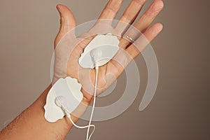 Man using an Electro Therapy Massager or Tens Unit on his hand