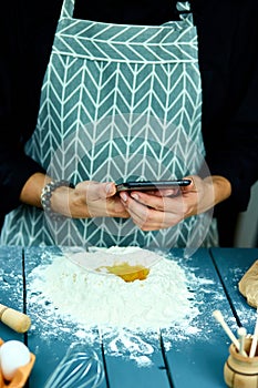 Man using electronic tablet pc in kitchen for baking.