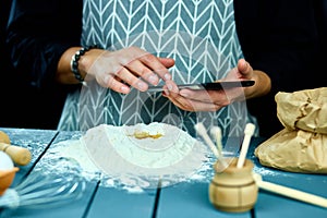 Man using electronic tablet pc in kitchen for baking. Man searching for food recipe in tablet computer.