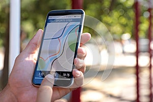 Man using fitness app on smartphone outdoors, closeup