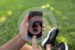 Man using fitness app on smartphone outdoors, closeup