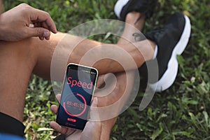 Man using fitness app on smartphone outdoors, closeup