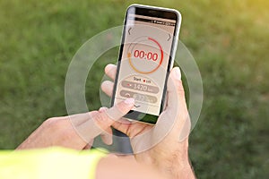 Man using fitness app on smartphone outdoors, top view