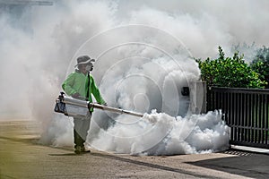 Man using fogger machine to control dangerous from mosquitoes