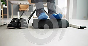 Man Using Footrest To Reduce Back Strain