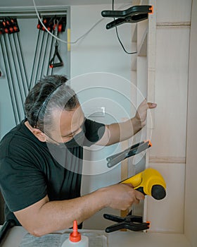 Man using Framing Nailer to attach wooden plywoods