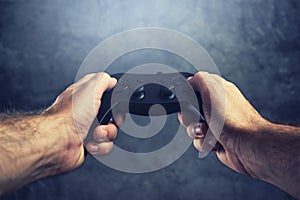 Man using gamepad controller to play video games