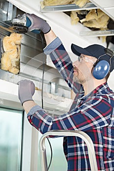 man using grinder on window