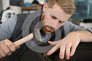 man using hammer to tap wheel
