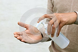 Man using hand press bottle and pouring alcohol-based sanitizer on other hand