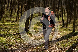 Man using hiking sticks poles outdoors in woods.