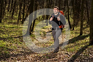 Man using hiking sticks poles outdoors in woods.