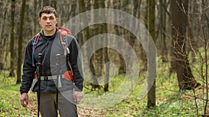 Man using hiking sticks poles outdoors in woods.