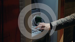 Man using his credit card in an atm for cash withdrawal, pin code money shopping mall or city street europe