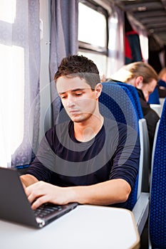 Man using his laptop computer while on the train