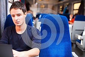 Man using his laptop computer while on the train