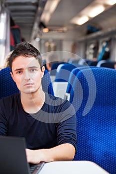 Man using his laptop computer while on the train