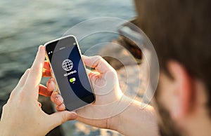 Man using his mobile phone on the coast roaming