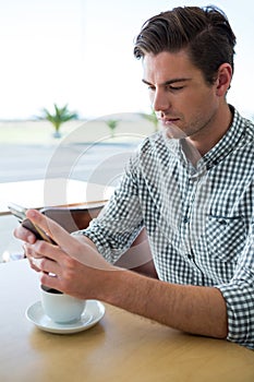 Man using his mobile phone in coffee shop