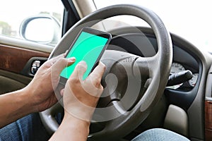 Man Using his mobile phone while driving. Dangerous driver. Blue / Green Screen.