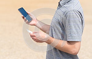 Man using his phone and holding card