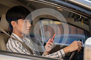 A man using his smartphone while driving a car. A man using map on his phone while driving