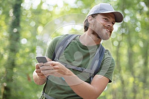 man using smartphone in forest
