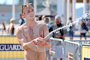 A man using a hose to wet the audience in a summer day at LKXA Extreme Sports Barcelona Games