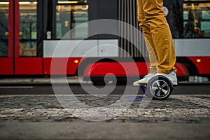 Man is using hoverboard against the background of the tram