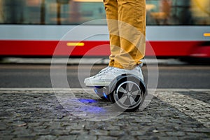 Man using hoverboard against the background of the tram