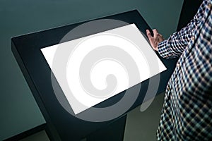 Man using interactive white empty touchscreen display kiosk at exhibition