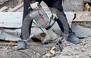 A man is using a jackhammer to break up concrete