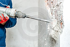 Man using a jackhammer to drill into wall