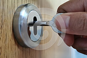Man using a key to open the door.