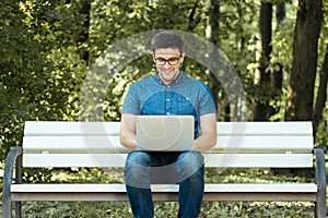 Man using laptop in city park