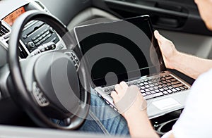 Man using laptop computer in car