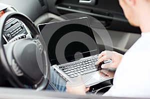 Man using laptop computer in car